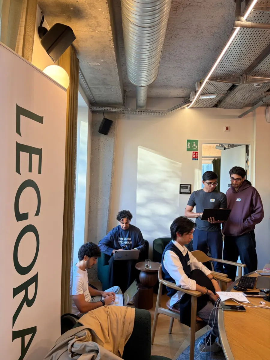 The team at work during the day, beside a Legora banner